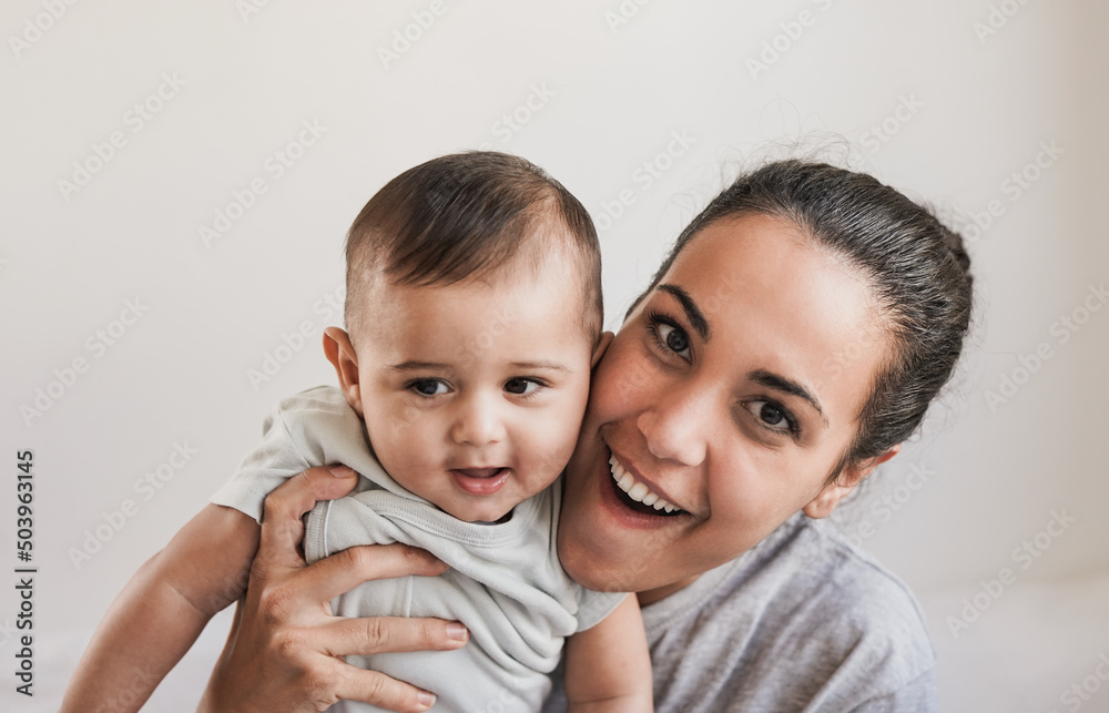 Young mother holding toddler and smiling on camera - Family, mother and child love concept Young mother holding toddler and smiling on camera - Family, mother and child love concept