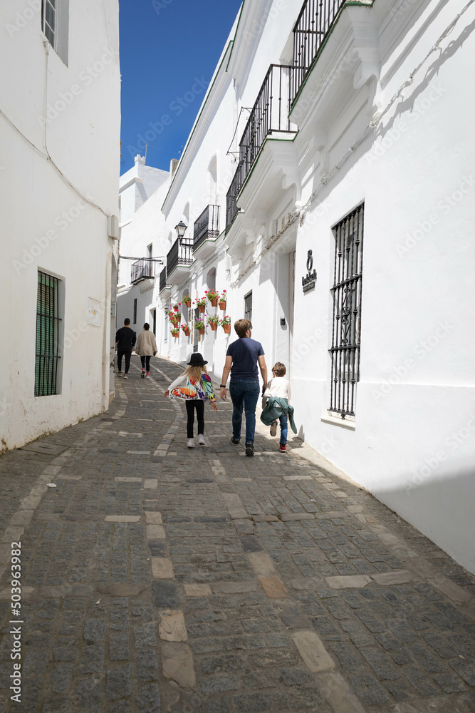 Mono parental family, twin kids, on holidays in a mediterranean white village in Cadiz, Spain. Whitewashed houses.