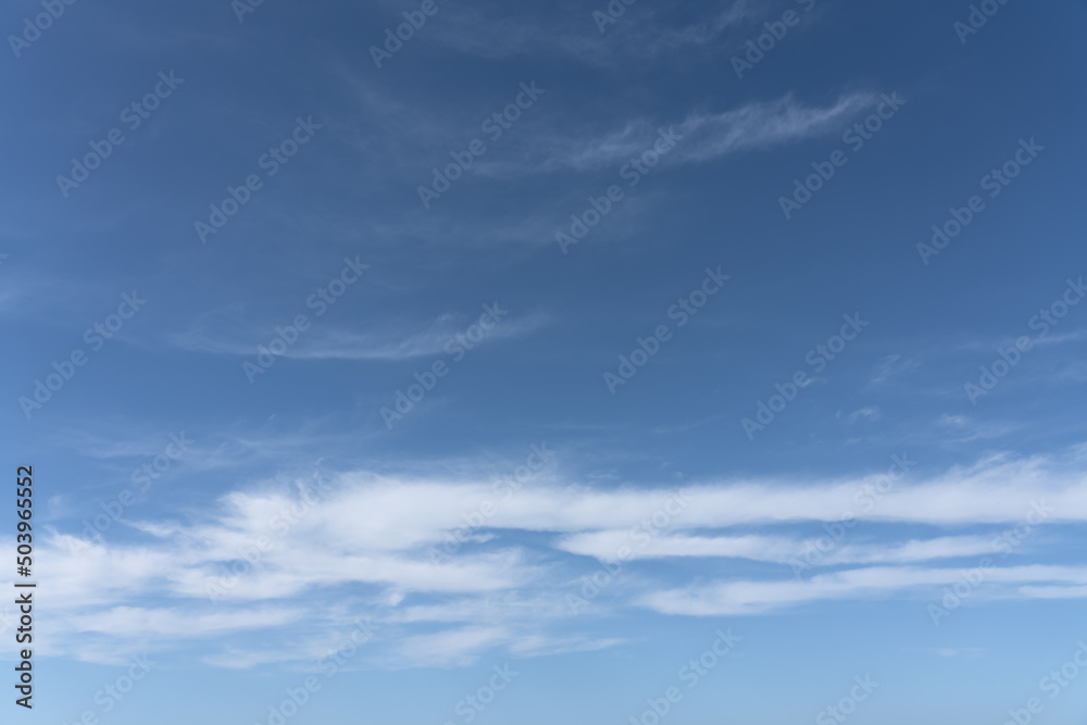 Gentle white clouds on clear blue sky