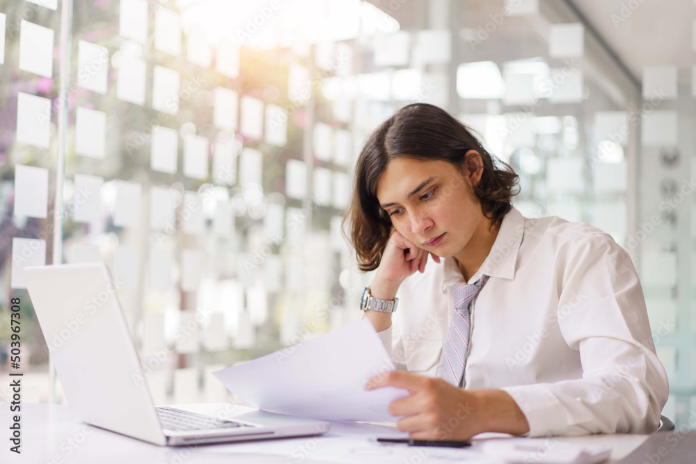 Business concept, Businessman reading financial report and analyze to make project on laptop