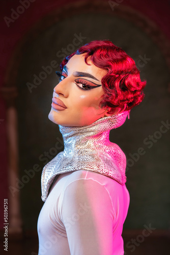 Fantasy portrait of a young man as a drag queen. Fashion trendy studio photography with glamourous makeup. Gender-fluid or non-binary identity concept 