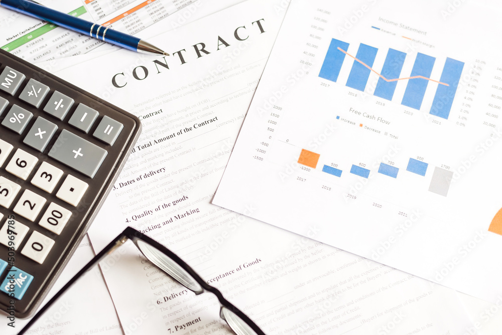 On the working table are a calculator, glasses, pen and diagrams. Top view close up business concept On the working table are a calculator, glasses, pen and diagrams. Top view close up business concept