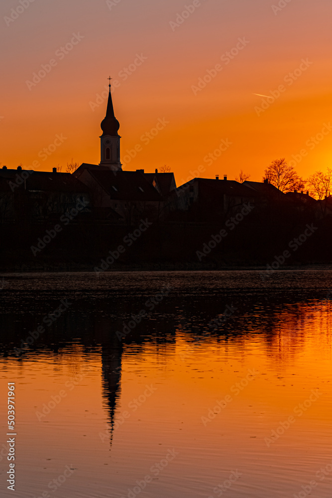 Beautiful sunset with reflections and a church silhouette near Pleinting, Danube, Bavaria, Germany