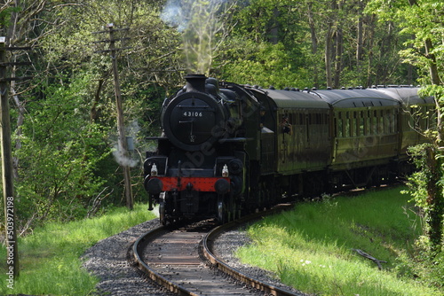 an Ivatt class 4 steam locomotive traveling through an English forest