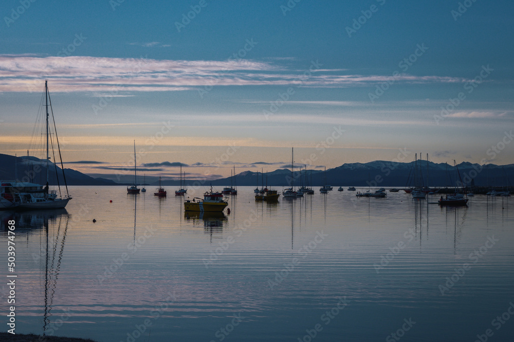 Fototapeta premium Wide angle view of the sea in a harbor during the sunset.