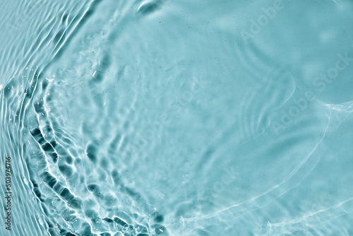 Trendy summer nature banner. Defocused aqua-mint liquid colored clear water surface texture with splashes bubbles. Water waves in sunlight background. 