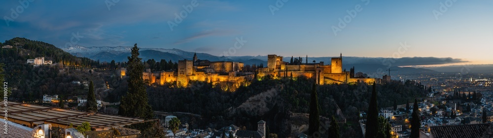 Panoramic photography of the Alhambra and the castle of Carlos V in the background is the Sierra Nevada and the city of Granada in Spain, from the plaza del mirador de San Nicolas during sunset