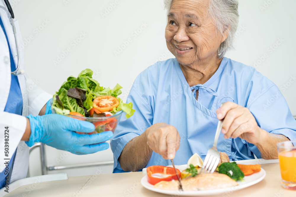 Asian senior or elderly old lady woman patient eating breakfast vegetable healthy food with hope and happy while sitting and hungry on bed in hospital. Asian senior or elderly old lady woman patient eating breakfast vegetable healthy food with hope and happy while sitting and hungry on bed in hospital.