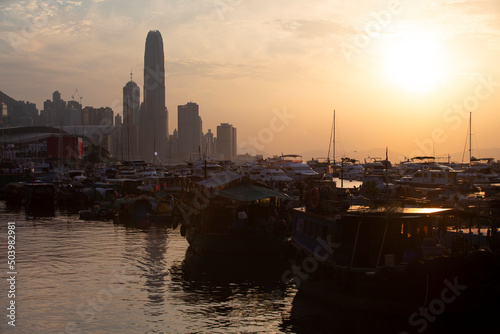  junk boats with the backlit of skyscrapers in Hong Kong island, the view of typhoon shelter