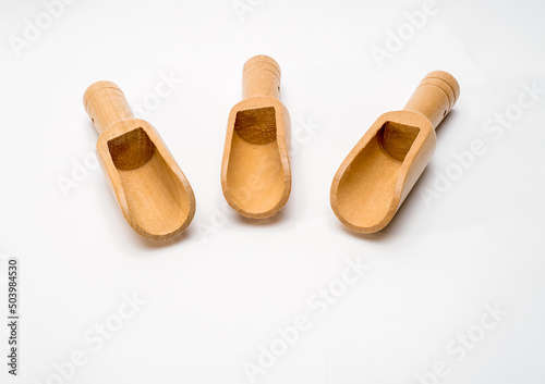 Selected focus small bamboo wood scoops spoons for measuring and pouring ingredients on a white background