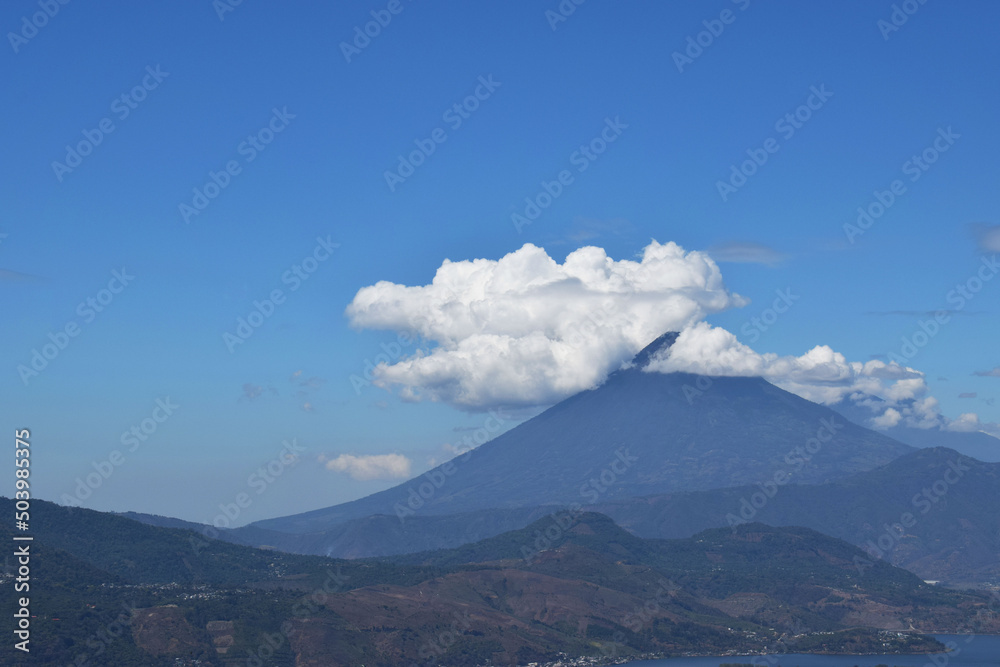 Volcán de Agua rodeado de nubes en Guatemala. Espacio para texto al lado izquierdo.
