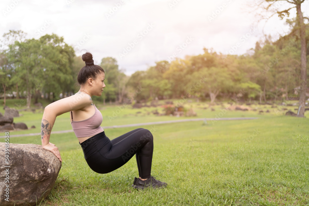 asian tattoo young woman doing yoga in the park asian tattoo young woman doing yoga in the park