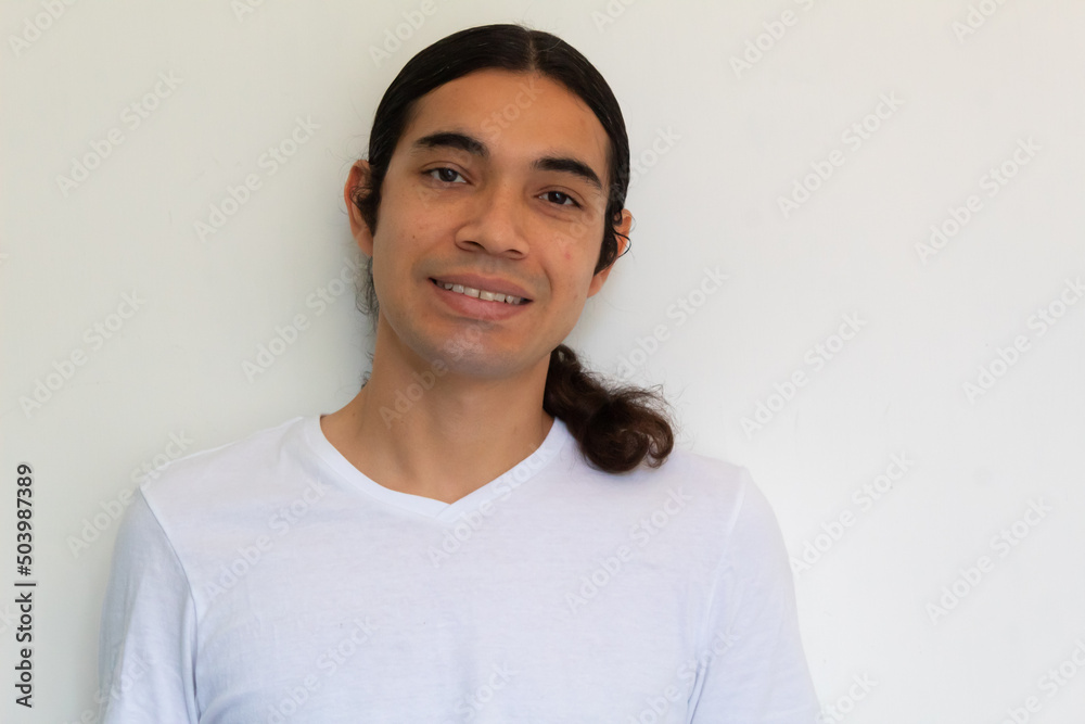 portrait of a non binary hispanic man with long hair on a white background portrait of a non binary hispanic man with long hair on a white background