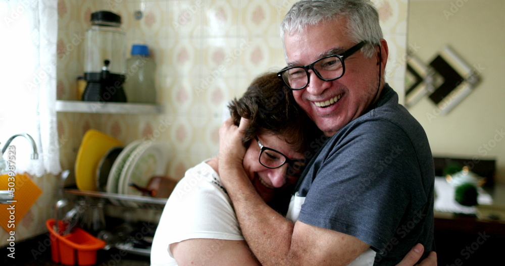 Happy husband hugging wife after receiving positive news on smartphone Happy husband hugging wife after receiving positive news on smartphone