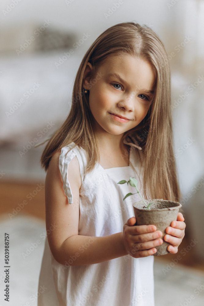 Cute adorable caucasian little girl at home with flowers. Smiling happy kid, childhood happiness concept Cute adorable caucasian little girl at home with flowers. Smiling happy kid, childhood happiness concept