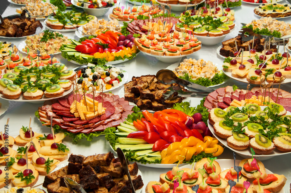 delicious dishes on the festive table. different food on the wedding table. the concept of celebrating an important event. buffet table with sandwiches and cold cuts delicious dishes on the festive table. different food on the wedding table. the concept of celebrating an important event. buffet table with sandwiches and cold cuts