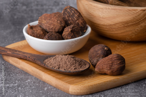 Fototapeta Naklejka Na Ścianę i Meble -  Black cardamom in a bowl.
Dry black cardamom spice close up. Black cardamom powder.