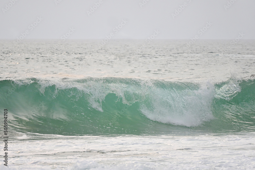 Fototapeta premium A powerful crystal green ocean wave on a beautiful beach, Phuket, Thailand.
