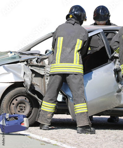firefighters as they remove the door of a car crashed after the road accident on the highway