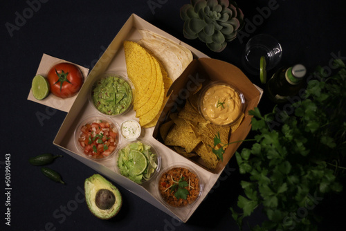Mexican food box, tex mex, Taco, chili, tortilla, nachos chips, cheddar cheese, guacamole, sour cream, lettuce, tomato