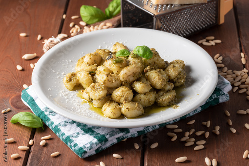 Piatto di deliziosi gnocchi di patate con pesto alla genovese, cibo Italiano photo