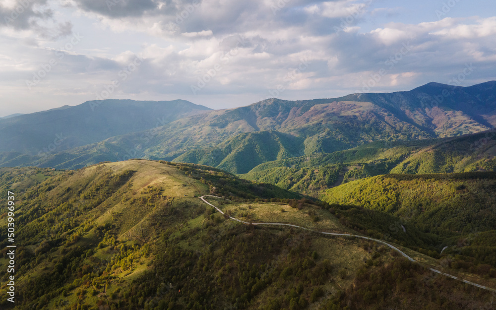 High angle aerial view drone image of sunset sun rays trough the trees and forest in mountain range in autumn or winter day - Babin Zub Old Mountain in Serbia - Travel journey and vacation concept