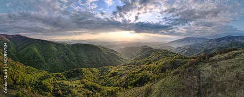 High angle aerial view drone image of sunset sun rays trough the trees and forest in mountain range in autumn or winter day - Babin Zub Old Mountain in Serbia - Travel journey and vacation concept © Miljan Živković