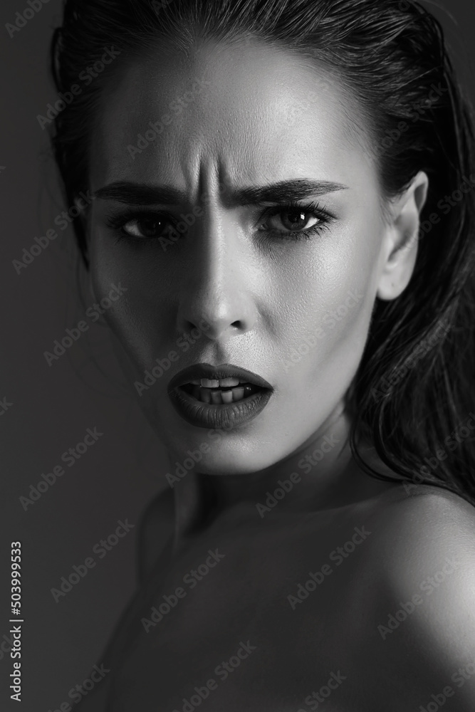 ant and surprised glamor brunette woman with a wrinkle on her forehead, dissatisfied with aging and the appearance of wrinkles on her skin. Female with red lips and open mouth