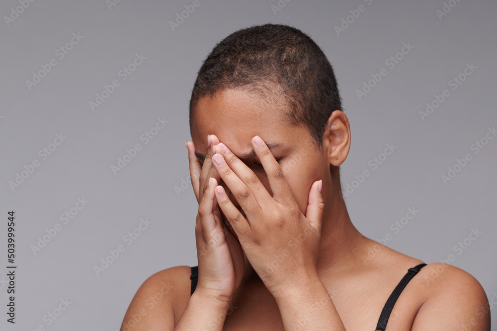 Frustrated young black woman covering face with hands while crying in despair, black lives matter concept Frustrated young black woman covering face with hands while crying in despair, black lives matter concept