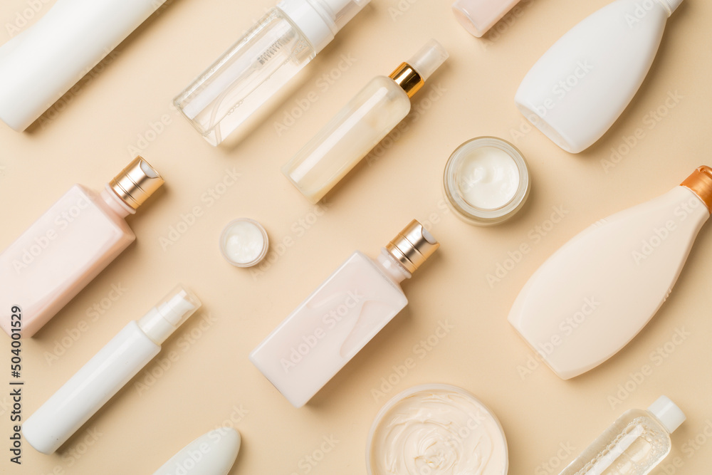 Different cosmetic bottles and container on color background, top view Different cosmetic bottles and container on color background, top view