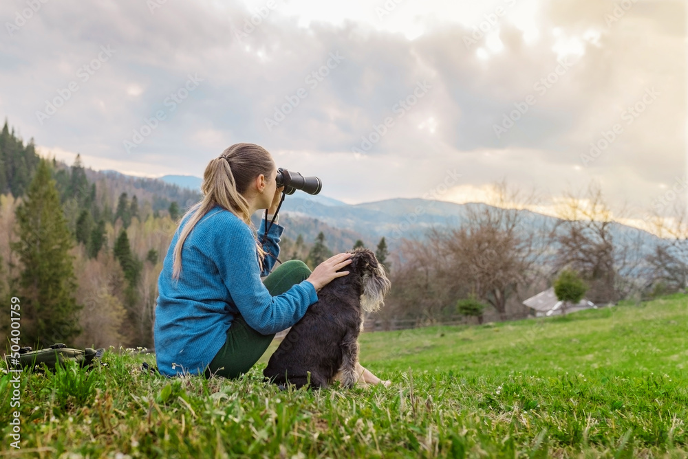 beautiful young girl with the dog looking through binoculars in nature in the mountains beautiful young girl with the dog looking through binoculars in nature in the mountains