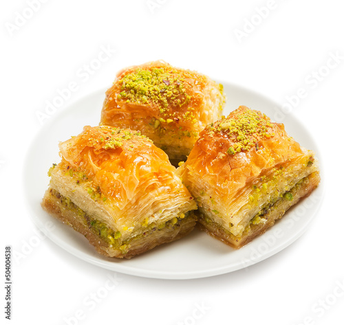 baklava with pistachios, 3 pieces, on a white plate, isolated, side view, close-up photo