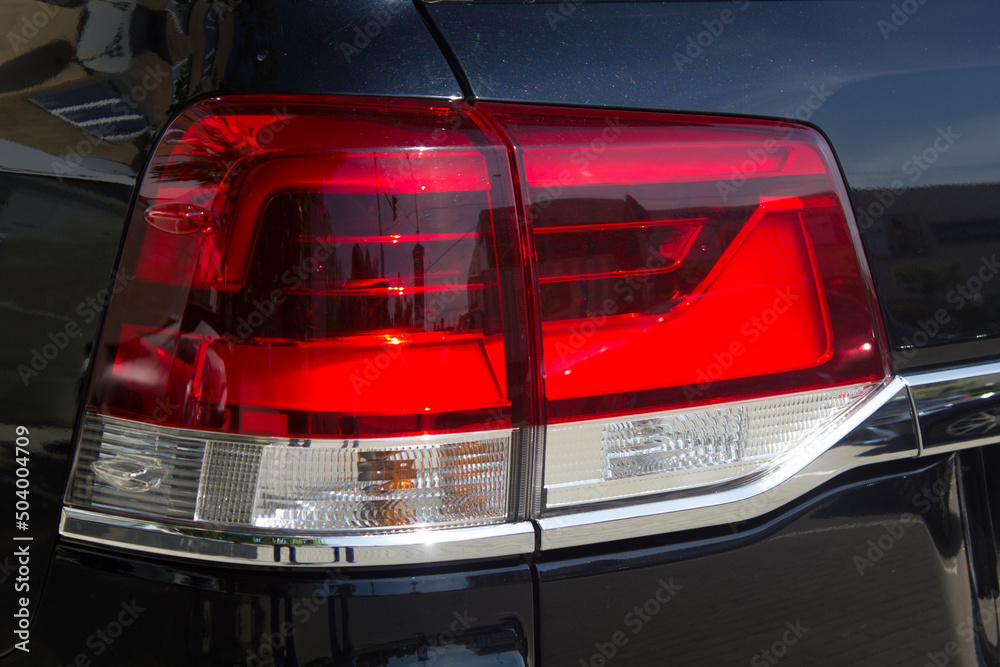 Rearview of a new black car. Close-up of car headlights. Black premium urban crossover, luxury SUV rear light close-up. Automobile lamp close-up.