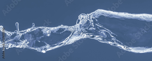 Water splash on a blue background. Reflection on the surface of the water. © iKatod