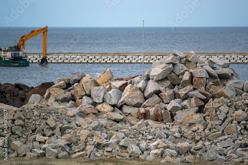 Plac budowy plaża materiały budowlane betonowe bloczki i kamienie, głazy, zwały piasku. 