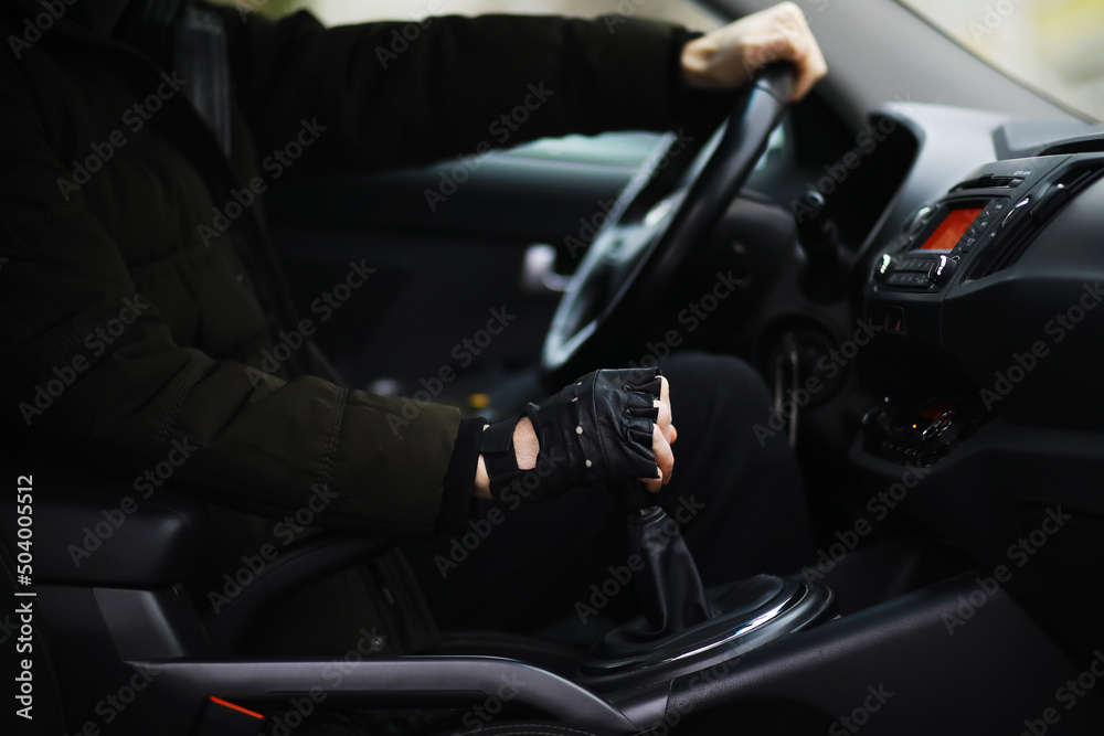 Hand on the car gear knob. The driver switches the speed in the car. Hand on gear lever.