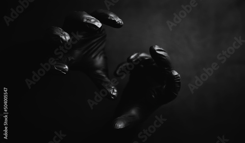 Background of hands in black gloves. Horror and hand monsters. Black hand gestures.