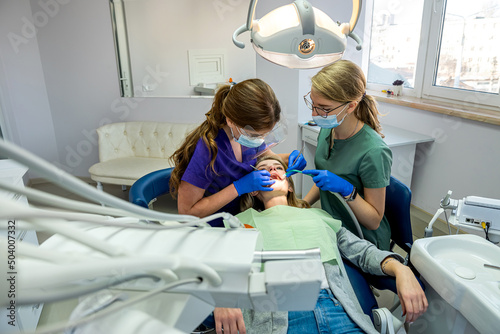 professional treating female patient teeth at dental clinic