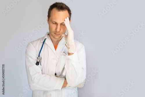 Handsome doctor man wearing medical uniform over isolated background tired rubbing nose and eyes feeling fatigue and headache. Stress and frustration concept.