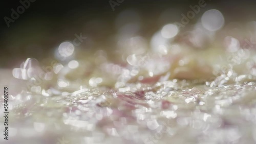 Close up tracking shot of chopped onion being sauteed in hot sizzling butter in skillet