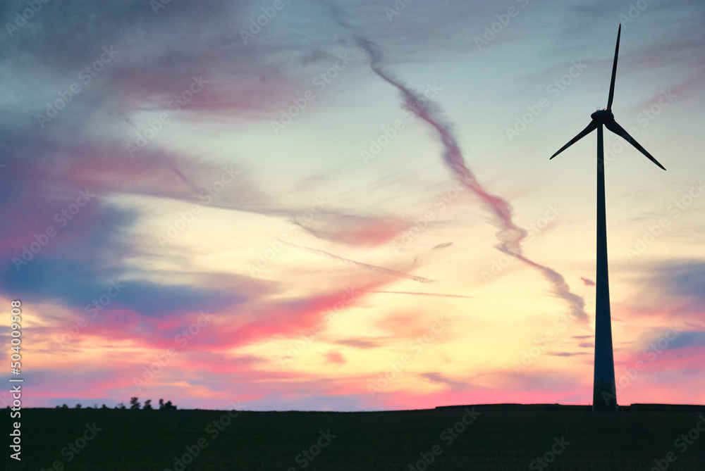 wind farm windmills in dramatic light and mystical sunset atmosphere