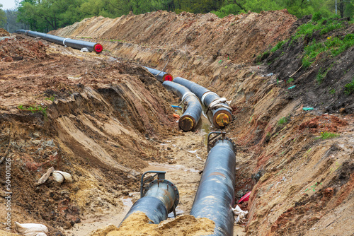 Gas pipeline under construction. Black pipes buried in the ground.
