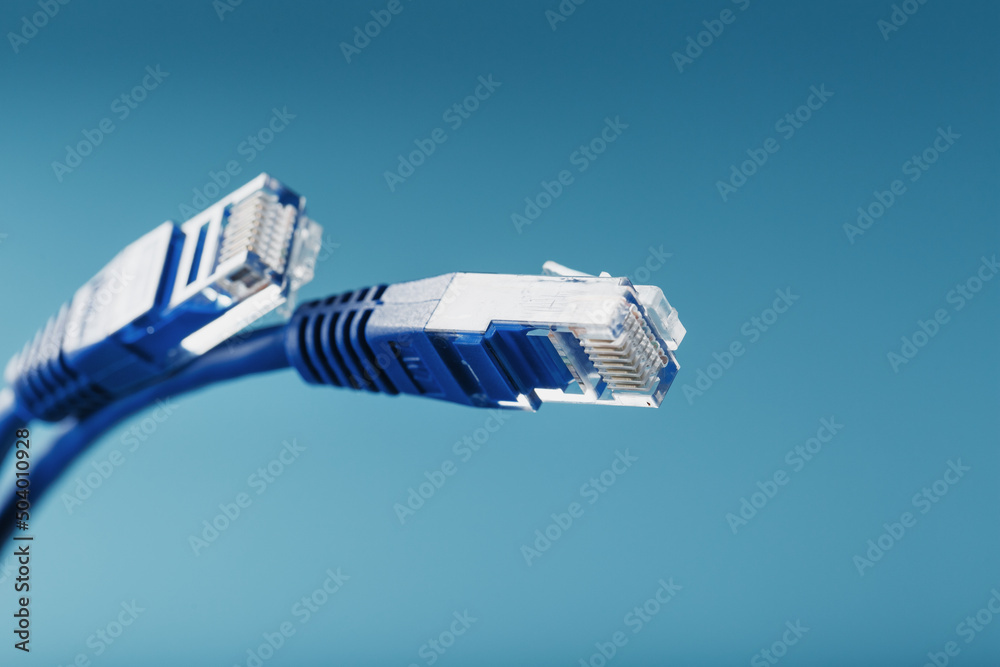 Two Ethernet Cable Connectors Patch cord cord close-up isolated on a blue background with free space Two Ethernet Cable Connectors Patch cord cord close-up isolated on a blue background with free space