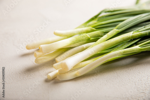 Fresh green onions on a gray stone background. Fresh greens. Salad onion. Vitamins.Copy space.Place for text.