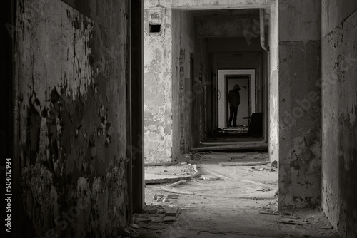 Ghost of a man in abandoned building. Silhouette in abandoned building. Ghost in corridor. Black and white photo.
