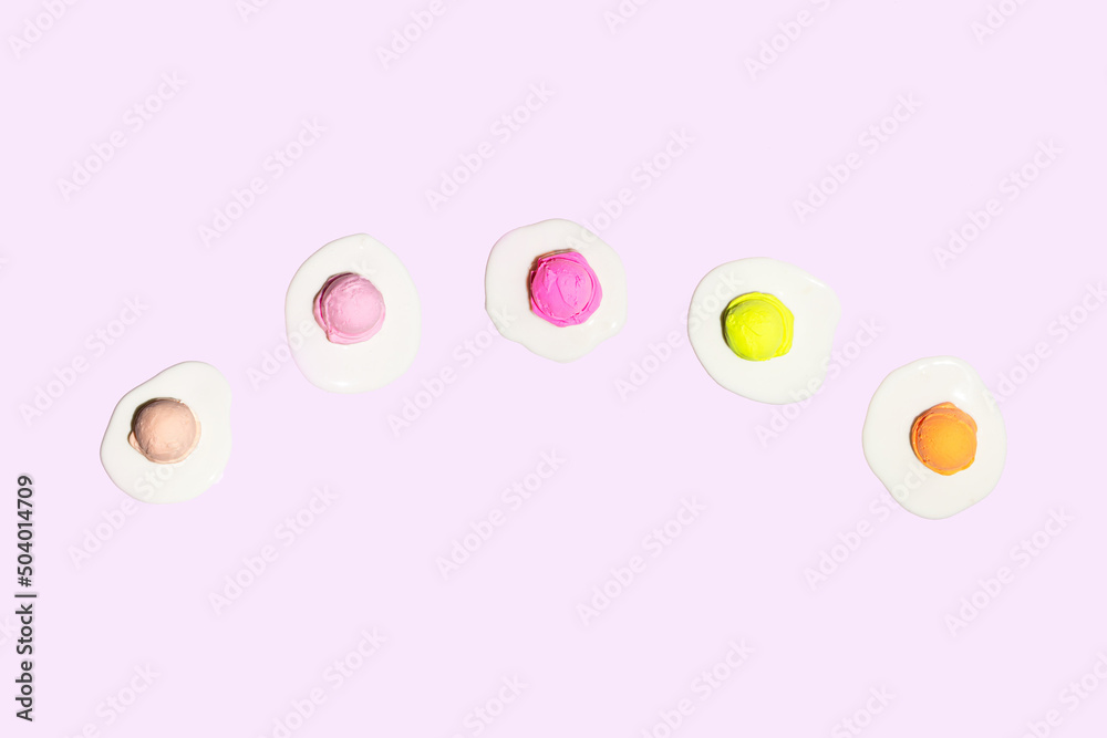 Paste ice cream balls as yolk on light pink background. Creative food concept. Minimalistic sweet and healthy food composition. Sunny summer idea.