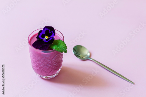 Obraz na płótnie Blackcurrant berry mousse garnished with viola flower and lemon balm leaf. w salonie