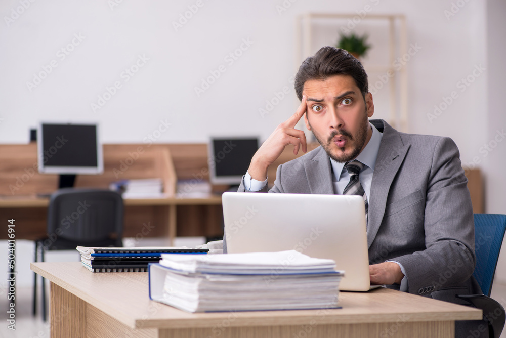 Young male employee working in the office Young male employee working in the office