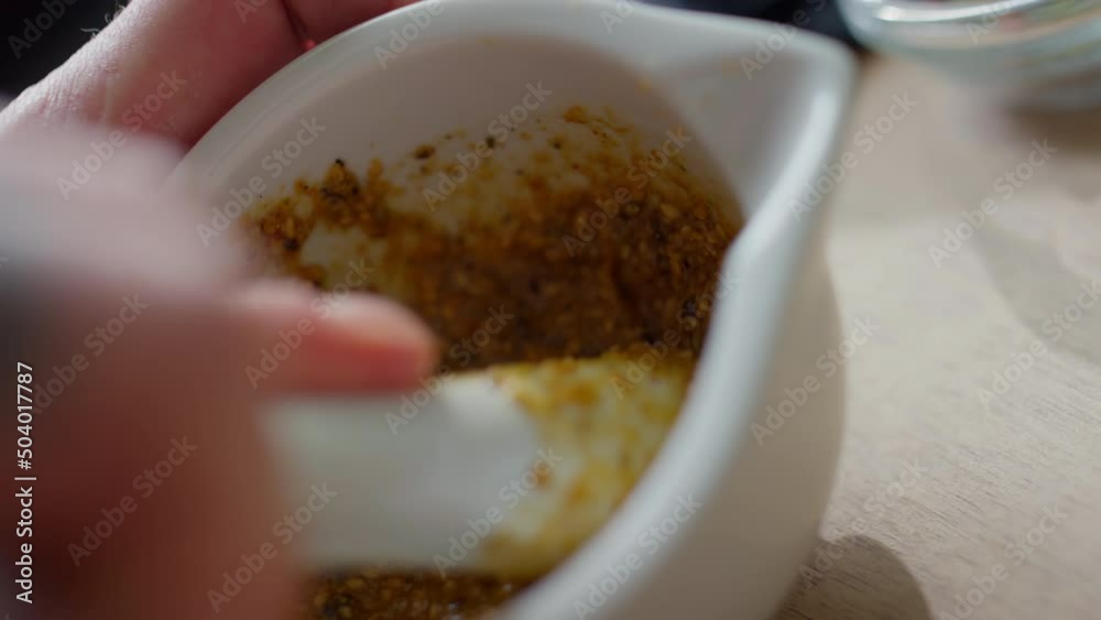Close up shot of preparing paste from tpasted sesame seeds with mortar and pestle