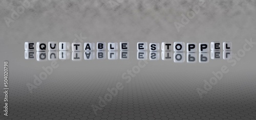 equitable estoppel word or concept represented by black and white letter cubes on a grey horizon background stretching to infinity photo